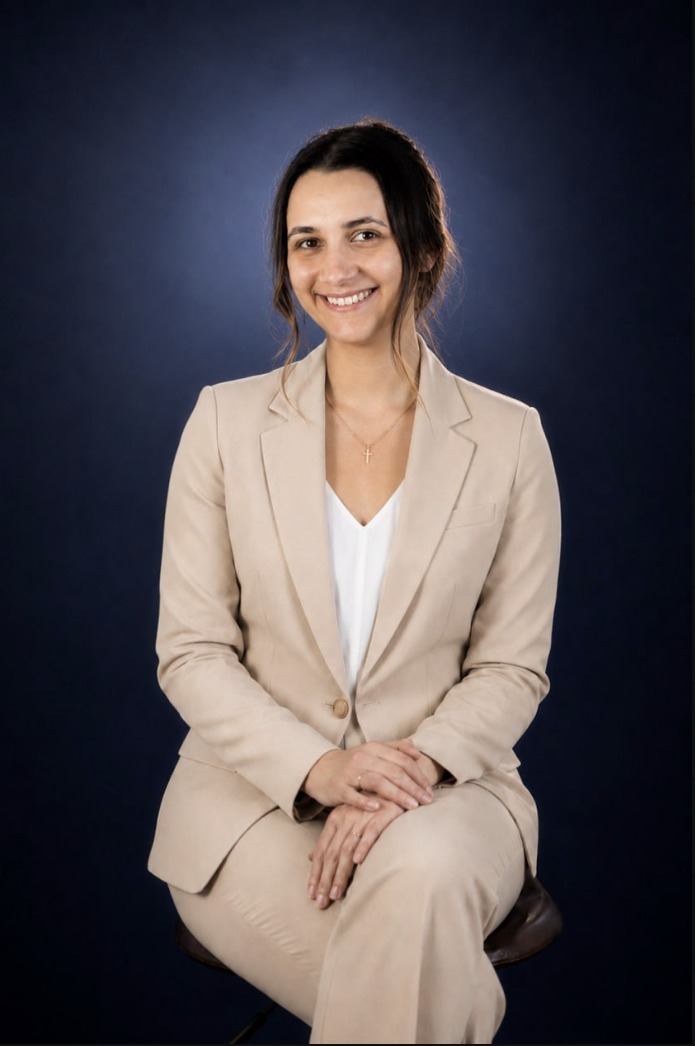 Retrato de estudio de Heidi Sanchez Pau, sentada con un blazer color crema, sonriendo a la cámara